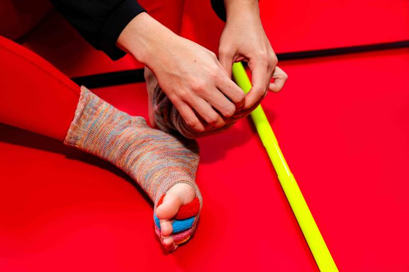 Red Original Foot Alignment Socks featured at Rose Physical Therapy; a professional-grade alternative to silicone spacers that uses fabric dividers to gently realign toes and alleviate plantar fasciitis and bunion pain