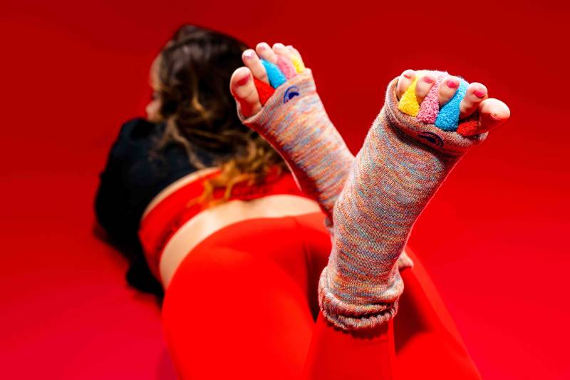 Vibrant red socks with integrated toe spacers designed to alleviate chronic foot pain and improve alignment, a non-invasive supplement to physical therapy for D.C. residents with hammer toes.