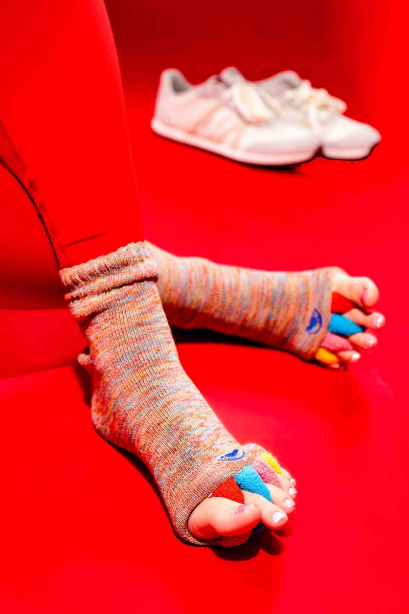 Professional foot alignment socks in red, featuring four toe separators to assist Rose Physical Therapy patients in Washington, D.C. with stretching and realigning toes for improved mobility.